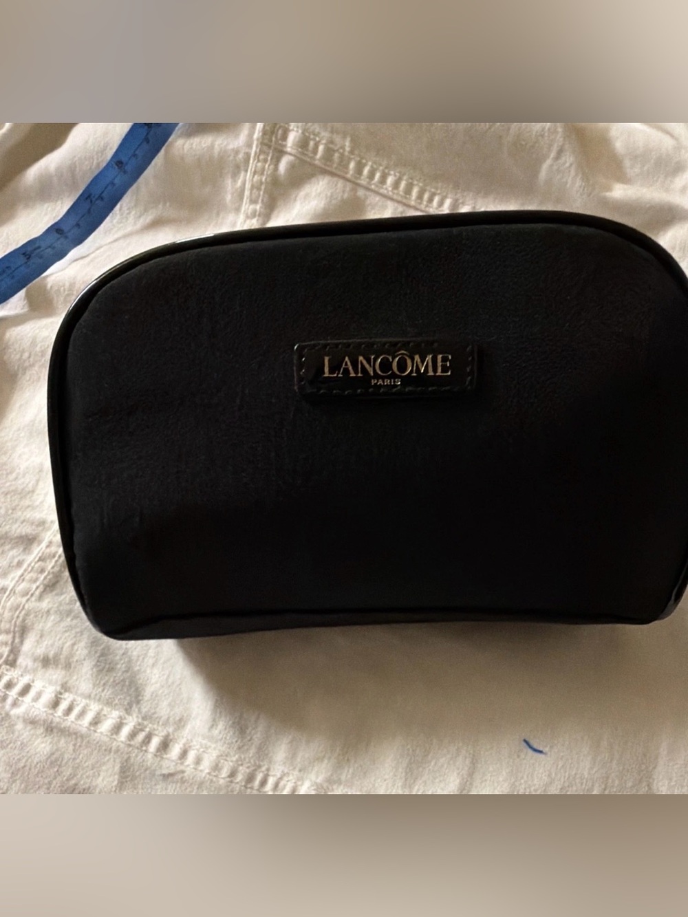 black faux-suede Lancôme Paris cosmetic pouch featuring a gold-lettered brand lo